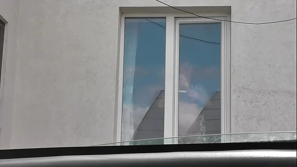 Sexy MILF Frina in dressing gown without panties and bra washes windows of apartment and is not shy about random taxi driver on street who looks out from his car. Naked in public. Nude in public. Public nudity. Publicly. Public. Natural tits Milf.